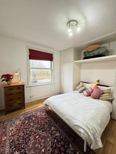 a bedroom with a large bed and a window at Spacious 4BD Family Home with GardenKensal Green! in London
