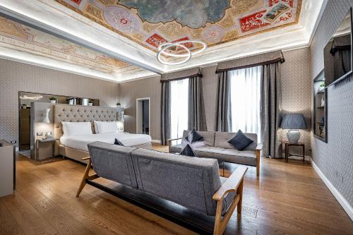 uma sala de estar com uma cama e um sofá em Martelli 6 Suite & Apartments em Florença