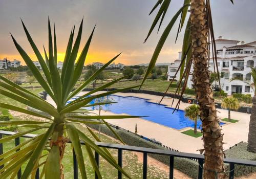 uma vista a partir da varanda de um resort com uma palmeira em Romantik M em Sucina