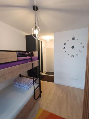 a room with bunk beds and a clock on the wall at Studio apartman Bjelašnica SAMBA in Bjelašnica