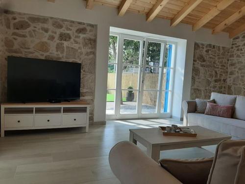 een woonkamer met een televisie en een bank bij Villa Laura - Home Away From Home in Labin