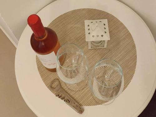 una bottiglia di vino e due bicchieri su un water di B&b Sedilequattro a Castellaneta