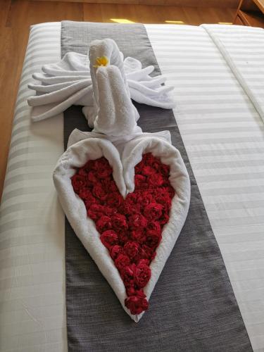 a heart with a white chicken and a pile of roses at Bukit Jaya Residence & Apartment Semarang in Semarang