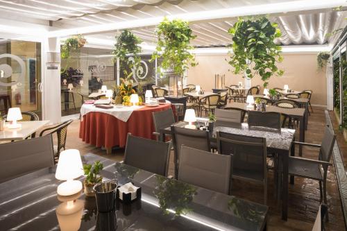 a restaurant with tables and chairs and plants at Hotel Roma in Sarria
