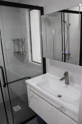 biała łazienka z umywalką i prysznicem w obiekcie Serene Modern Apartment w mieście Nairobi