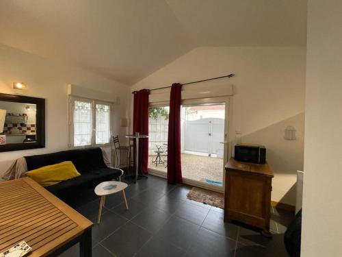 uma sala de estar com um sofá e uma grande janela em Les toits Vendôme em Lagord