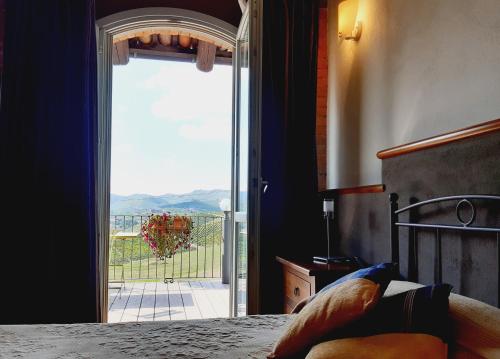 a bedroom with a large glass door to a balcony at Red Wine Camere in La Morra