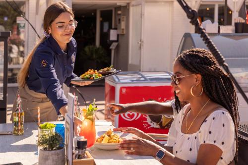 two women sitting at a table eating food at Summio Parc Aquadelta in Bruinisse