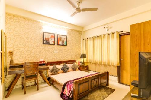 a bedroom with a bed and a desk at House Of Comfort Greater Noida Luxury in Greater Noida