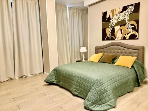 a bedroom with a green bed and a giraffe picture at Les Suites Luxury Bari Certified Italian Excellence in Bari