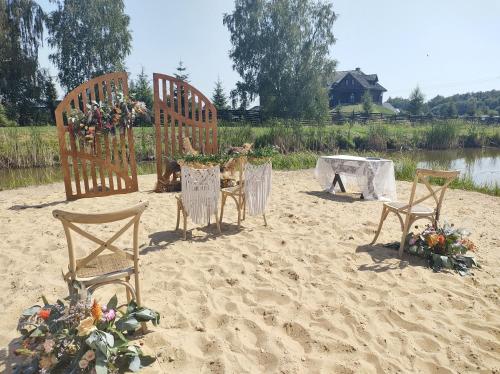 a couple of chairs and a table in the sand at Dom nad Rozlewiskiem in Zamość