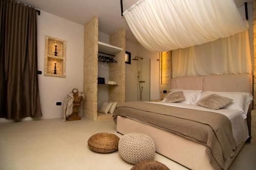 a bedroom with a large bed with two ottomans at Borgo Bevagna Relais in San Pietro in Bevagna