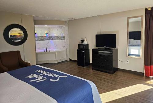 a bedroom with a bed and a flat screen tv at Days Inn by Wyndham Easley West Of Greenville/Clemson Area in Easley