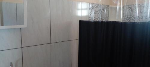 baño con ducha con cortina negra en Casa na lua, en São Thomé das Letras