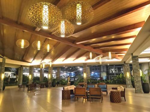 a lobby with tables and chairs and chandeliers at Verdon Parc 2Br Comfy Resort facing Samal island! in Davao City