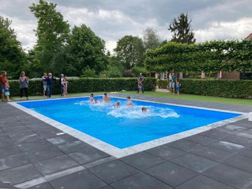 a group of people playing in a swimming pool at Chalet op mini-camping de Peelweide in Grashoek
