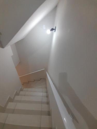un escalier avec une lumière au sommet d'un escalier dans l'établissement Residencial Mar Casado, à Guarujá