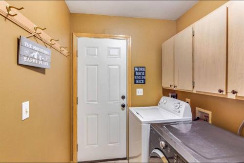 a laundry room with a washing machine and a white door at Basecamp Cabin in Greenwater