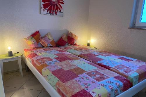 un letto con una trapunta in una camera da letto di FeWo Tietjen-Lohse, mit Meerblick, Strandhochhaus F9 a Cuxhaven