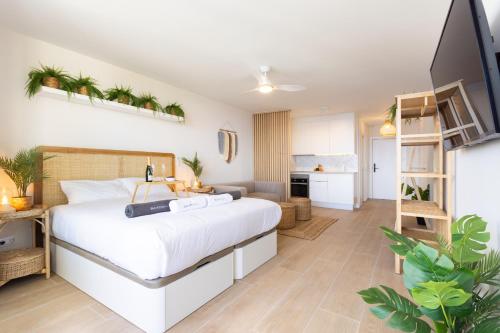 a bedroom with a large bed and a kitchen at Butan Suite in Callao Salvaje
