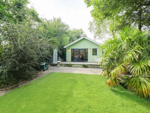 a green house with a lawn in front of it at Purrfect Retreat in Bugle