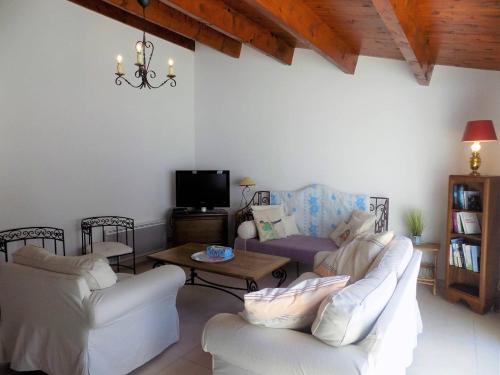 - un salon avec deux canapés blancs et une télévision dans l'établissement La Palmyre - TREMIERES - VILLA MITOYENNE - PROXIMITE PLAGE et CENTRE, aux Mathes