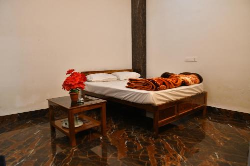 łóżko w pokoju ze stołem w obiekcie Paradise Inn w mieście Jasidih