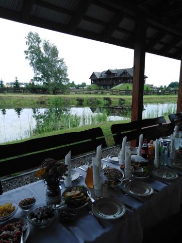 a table with food and a view of a river at Dom nad Rozlewiskiem in Zamość