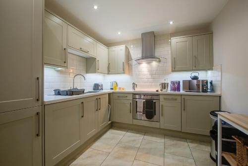 a kitchen with white cabinets and a sink at Spacious Townhouse on Quiet Street-Wi-Fi, Desk in Stamford