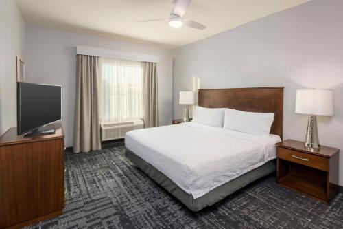 a hotel room with a bed and a flat screen tv at Homewood Suites by Hilton Phoenix North-Happy Valley in Phoenix