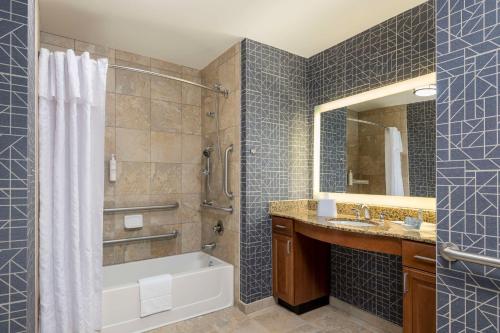 a bathroom with a tub and a shower and a sink at Homewood Suites by Hilton Phoenix North-Happy Valley in Phoenix