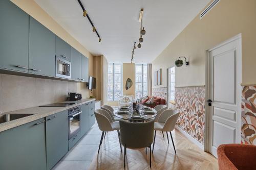 une cuisine et une salle à manger avec une table et des chaises dans l'établissement Apartment Le Marais by Studio prestige, à Paris