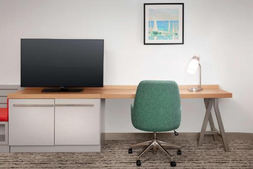 a desk with a computer monitor and a green chair at Hilton Garden Inn Solomons in Dowell
