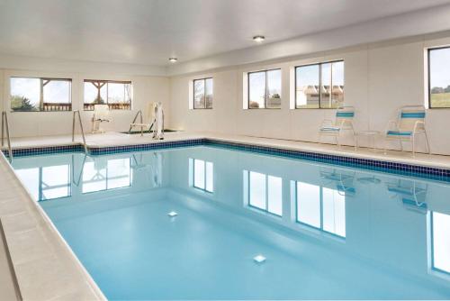 a swimming pool with blue water in a building at Super 8 by Wyndham Chambersburg I-81 in Chambersburg