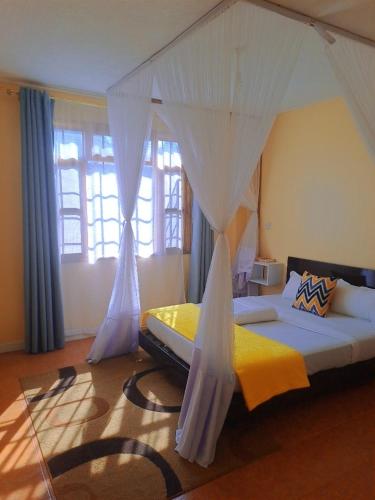 Elite stays kisumu في كيزيمو: غرفة نوم بسرير مع مظلة