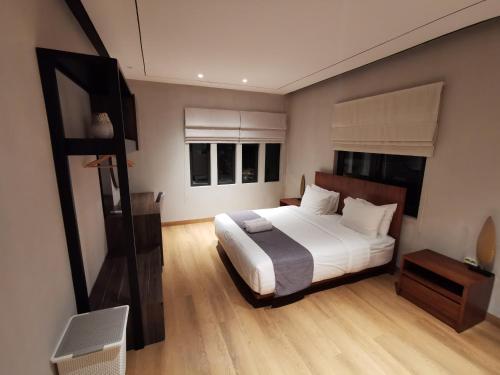 a bedroom with a large bed and two windows at Bukit Jaya Residence & Apartment Semarang in Semarang
