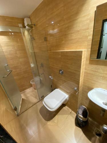 a bathroom with a toilet and a shower and a sink at The Majlis Hotel - Colaba Mumbai in Mumbai