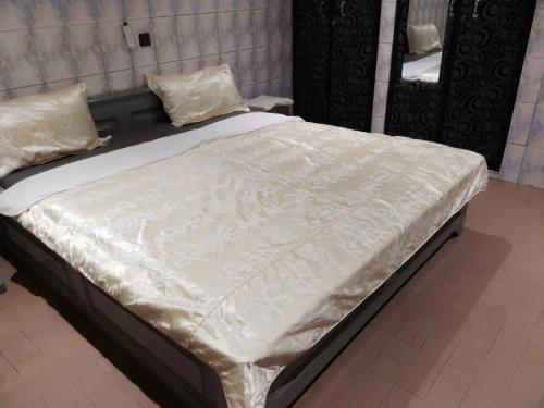 - un lit avec des draps et des oreillers blancs dans l'établissement Villa 28, à Lomé
