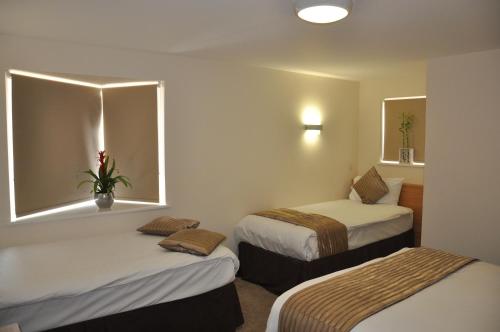 a hotel room with two beds and a window at Queens Hotel in London
