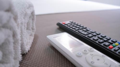 two remote controls are sitting next to a couch at Dom Hotel Maringá in Maringá
