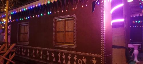 a building with purple lights and a window on it at Bendre's Farm Stay-Neral in Neral