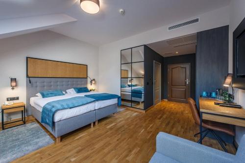 a bedroom with a bed and a desk in a room at Hotel Prezydent in Spała
