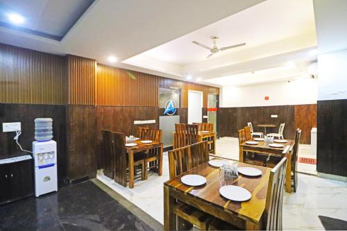 restauracja z drewnianymi ścianami, stołami i krzesłami w obiekcie Hotel Mayda Prime Near Delhi Airport w Nowym Delhi