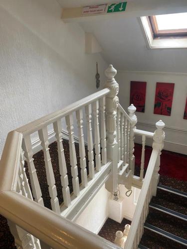 a staircase with white railings in a house at Villa Guest House in Porthcawl