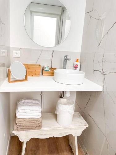 une salle de bain blanche avec un lavabo et un miroir dans l'établissement Studio Sable d'Or N1, à Aleçon