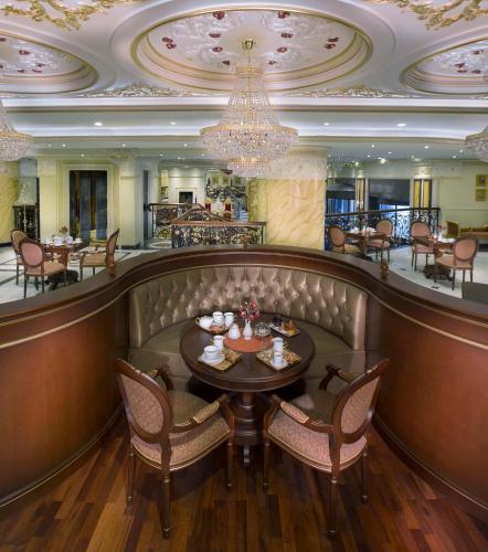 a restaurant with a table and chairs and a chandelier at Royal Rose Abu Dhabi, a Curio Collection by Hilton Affiliated Hotel in Abu Dhabi