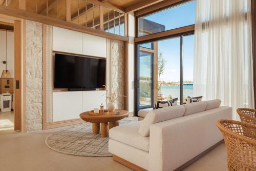 uma sala de estar com um sofá branco e uma grande janela em One&Only Aesthesis em Atenas