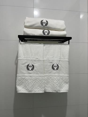 una pila de toallas blancas en un estante en Suíte Horto, en Ouro Preto