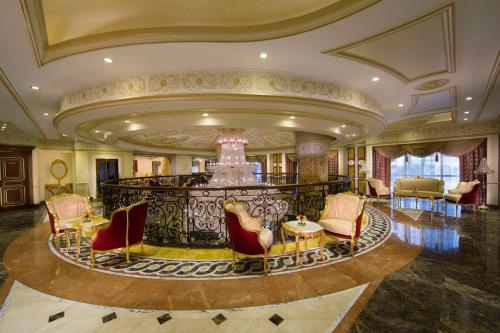 a lobby with chairs and a chandelier in a building at Royal Rose Abu Dhabi, a Curio Collection by Hilton Affiliated Hotel in Abu Dhabi