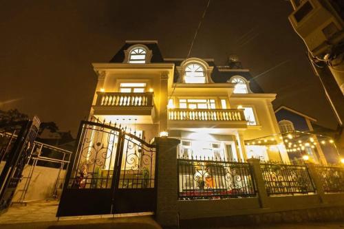a large yellow house with lights on it at night at CT Villa in Xuan An